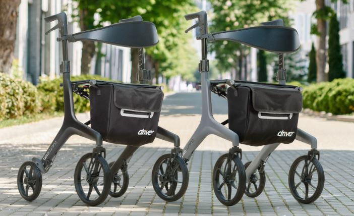 Drive Medical AeroCarbon Ultra-Lite Rollator in black and gray side by side on a city path