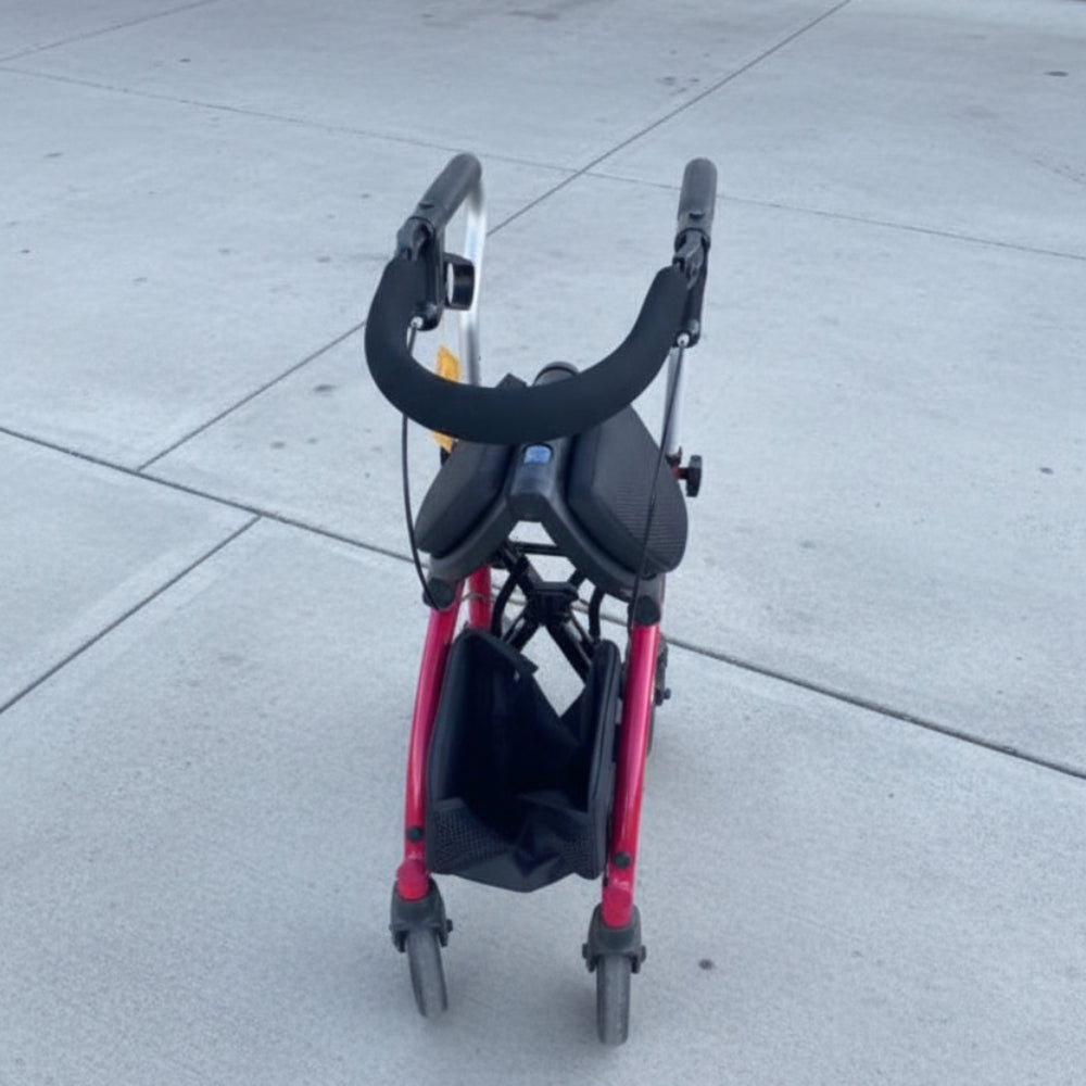 The Evolution Xpresso Lite rollator folded compactly side-to-side in a secure, self-standing upright position.