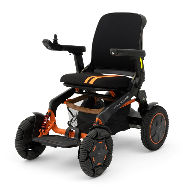 Robooter E60 Pro GT folding power wheelchair in orange and black, front three quarter view, showing its twelve inch omni directional front wheels and coil spring front suspension