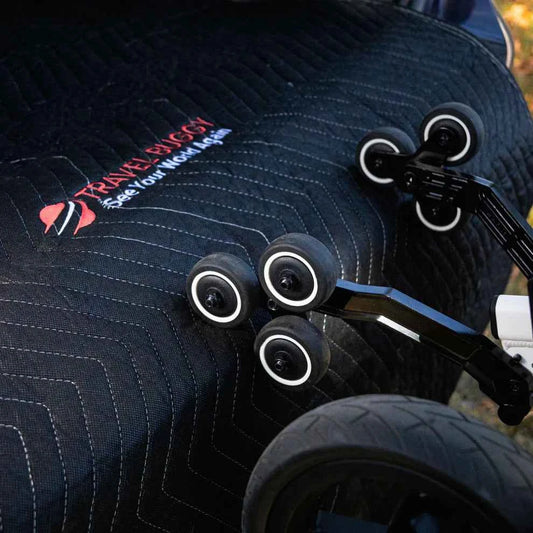 Close-up of a power wheelchair resting safely on the heavy-duty Travel Buggy protective bumper blanket.