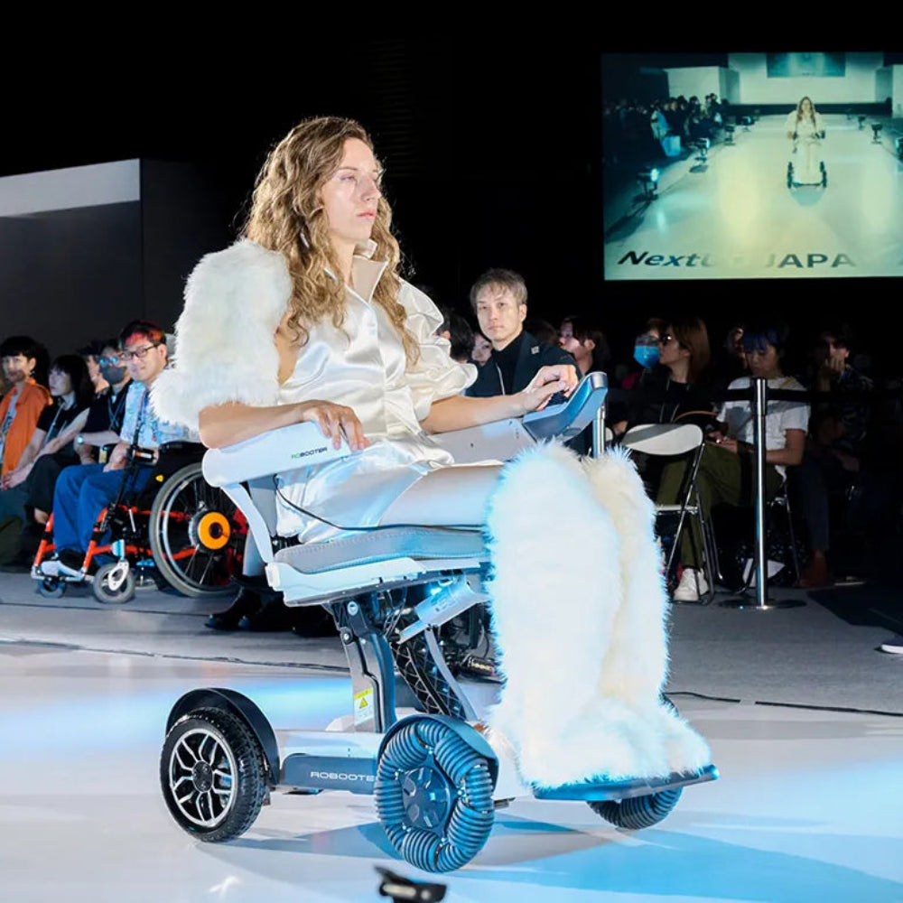 Lifestyle image of a woman navigating a spacious, modern audition hall using the sleek Robooter X40 electric wheelchair.