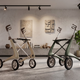 Two premium byACRE carbon fiber rollators—the Pearl White Ultralight and the Oyster Grey Overland—facing each other in a sunlit, modern Canadian living room with hardwood floors and large windows.