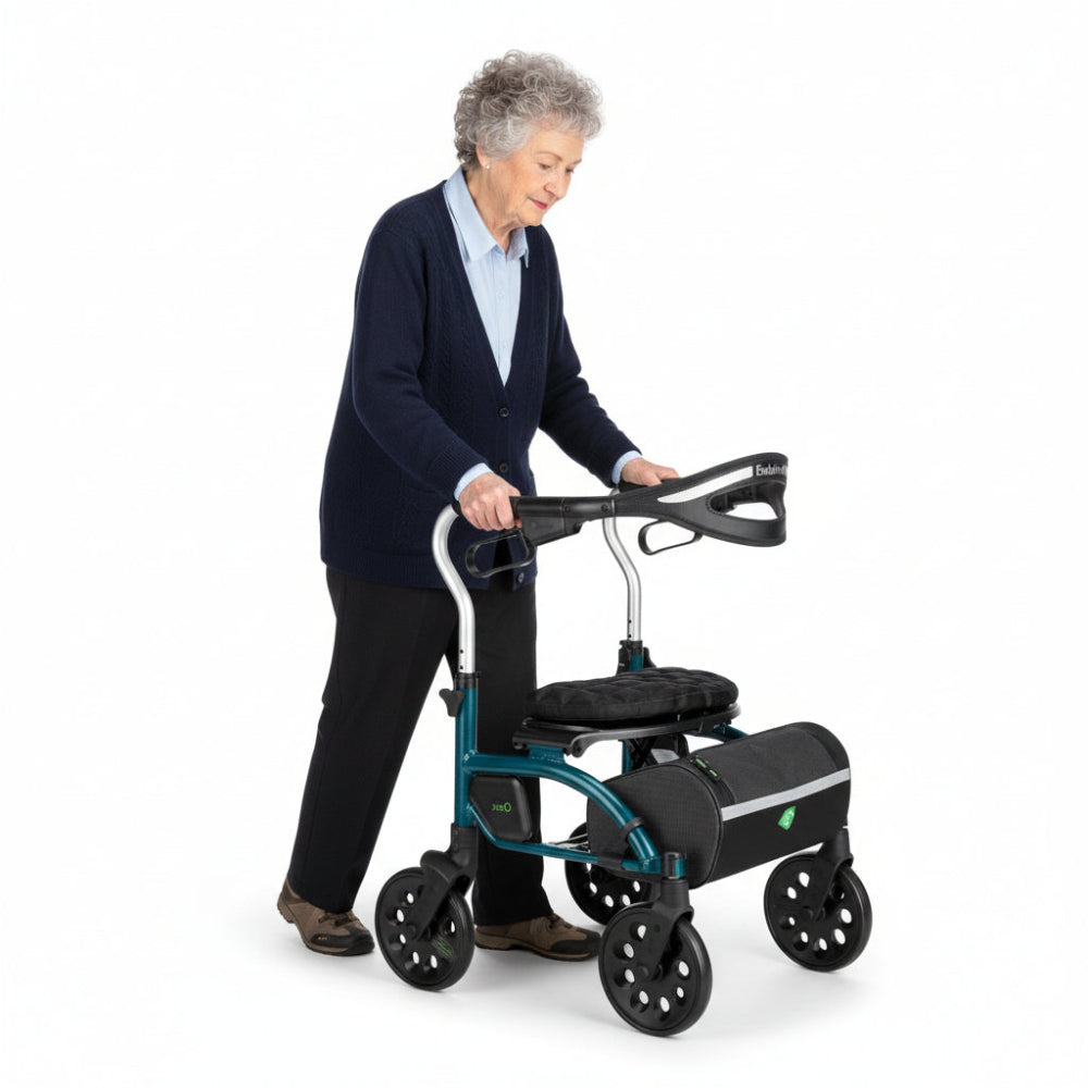 Lifestyle shot of a senior man confidently standing and holding the Evolution Xpresso Zero rollator in a modern indoor hallway.