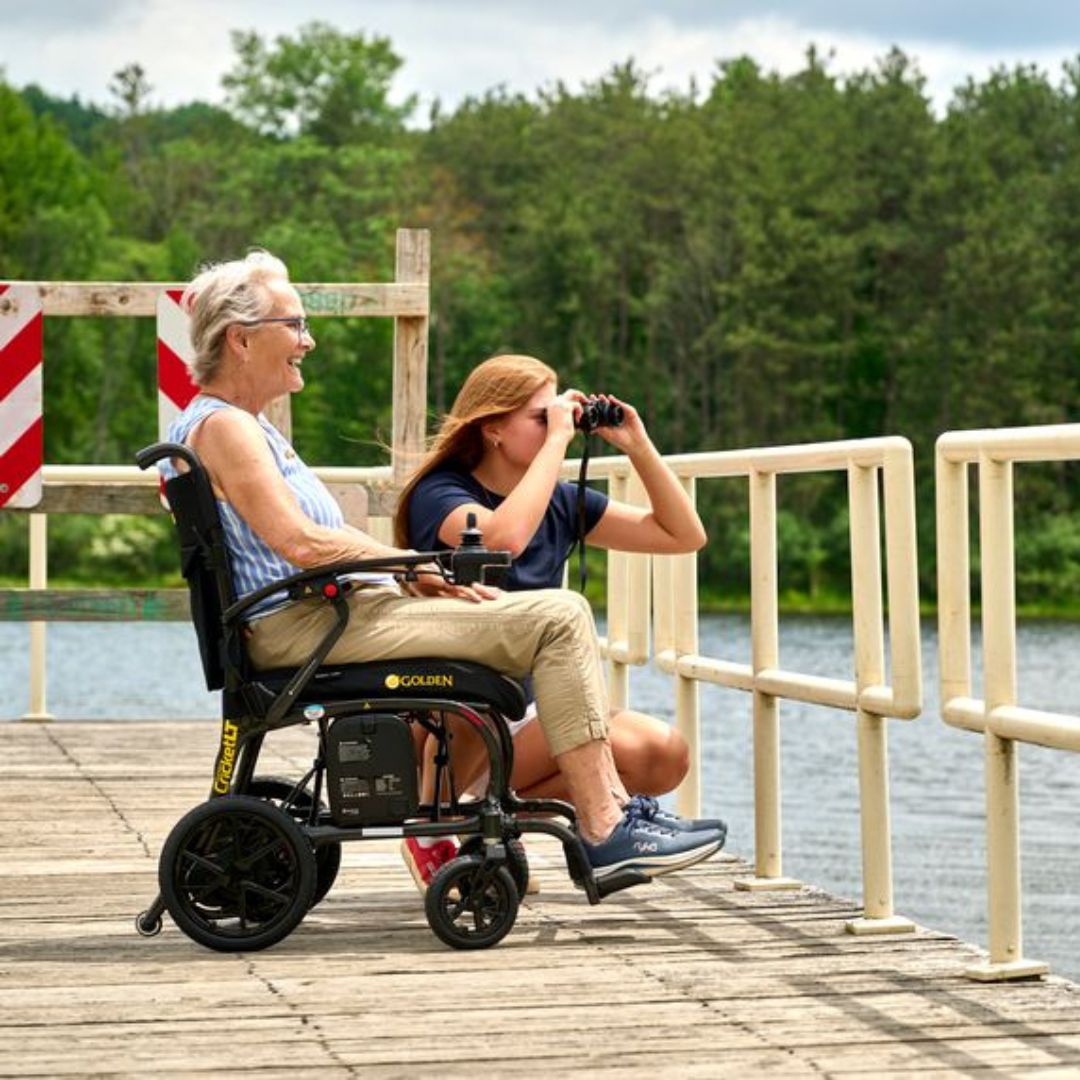 Woman using the Golden Cricket LT GP309 power wheelchair on a lakeside boardwalk
