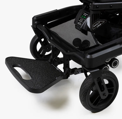 Close-up of the wide footrest, front wheels, and under-seat safety lock on the Travel Buggy Grand Tourer GT.