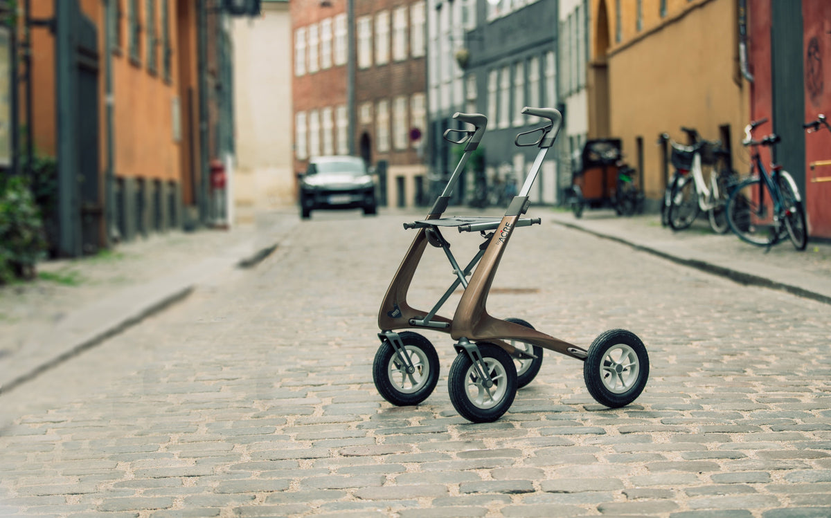 Bentley Brown byACRE Carbon Overland all-terrain rollator on a cobblestone street