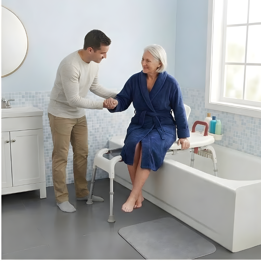 Lifestyle shot showing a caregiver effortlessly assisting a senior man into the bathtub using the Drive Medical sliding transfer bench.