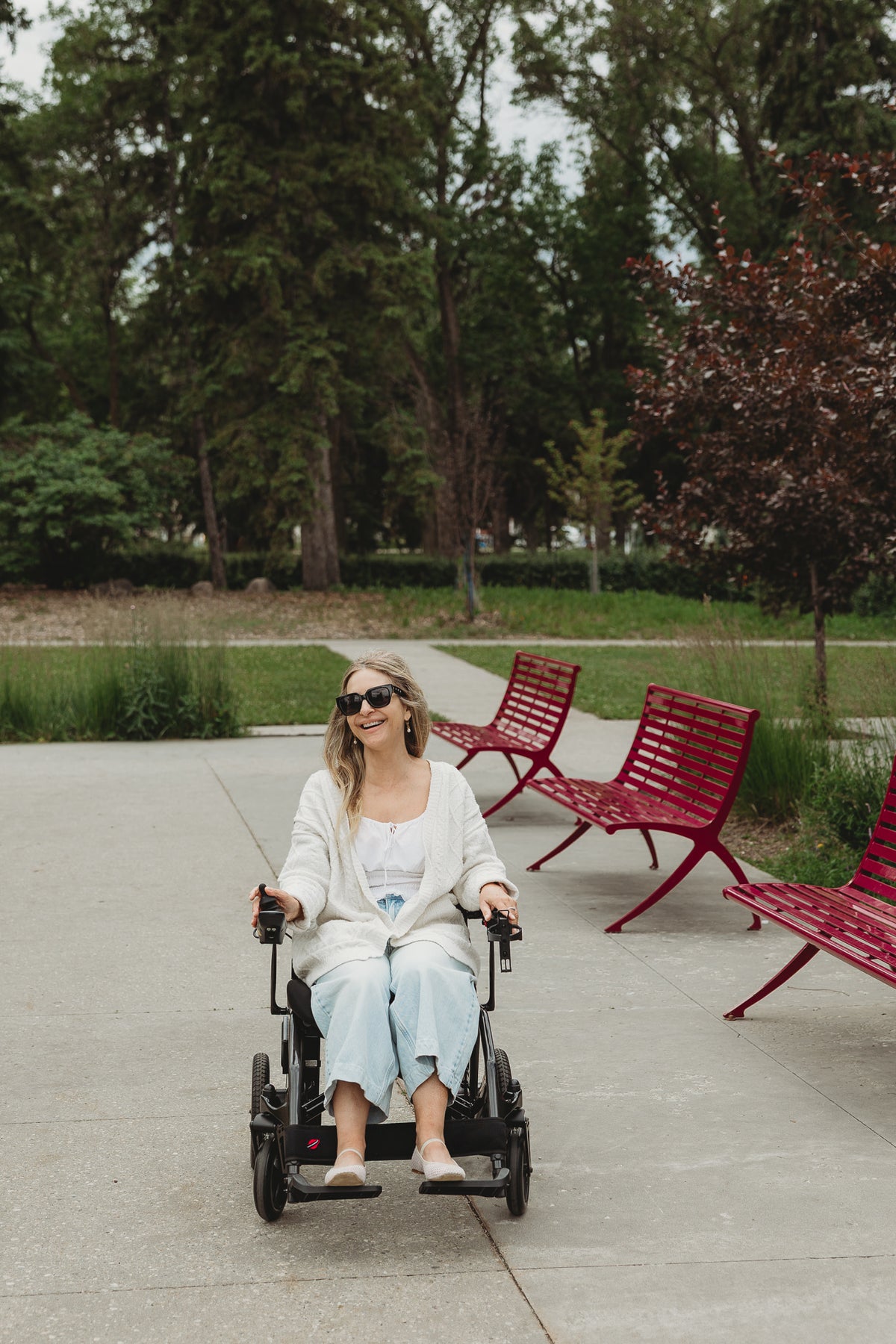Person using a Black Travel Buggy AEROLUX 2C power wheelchair on a park path