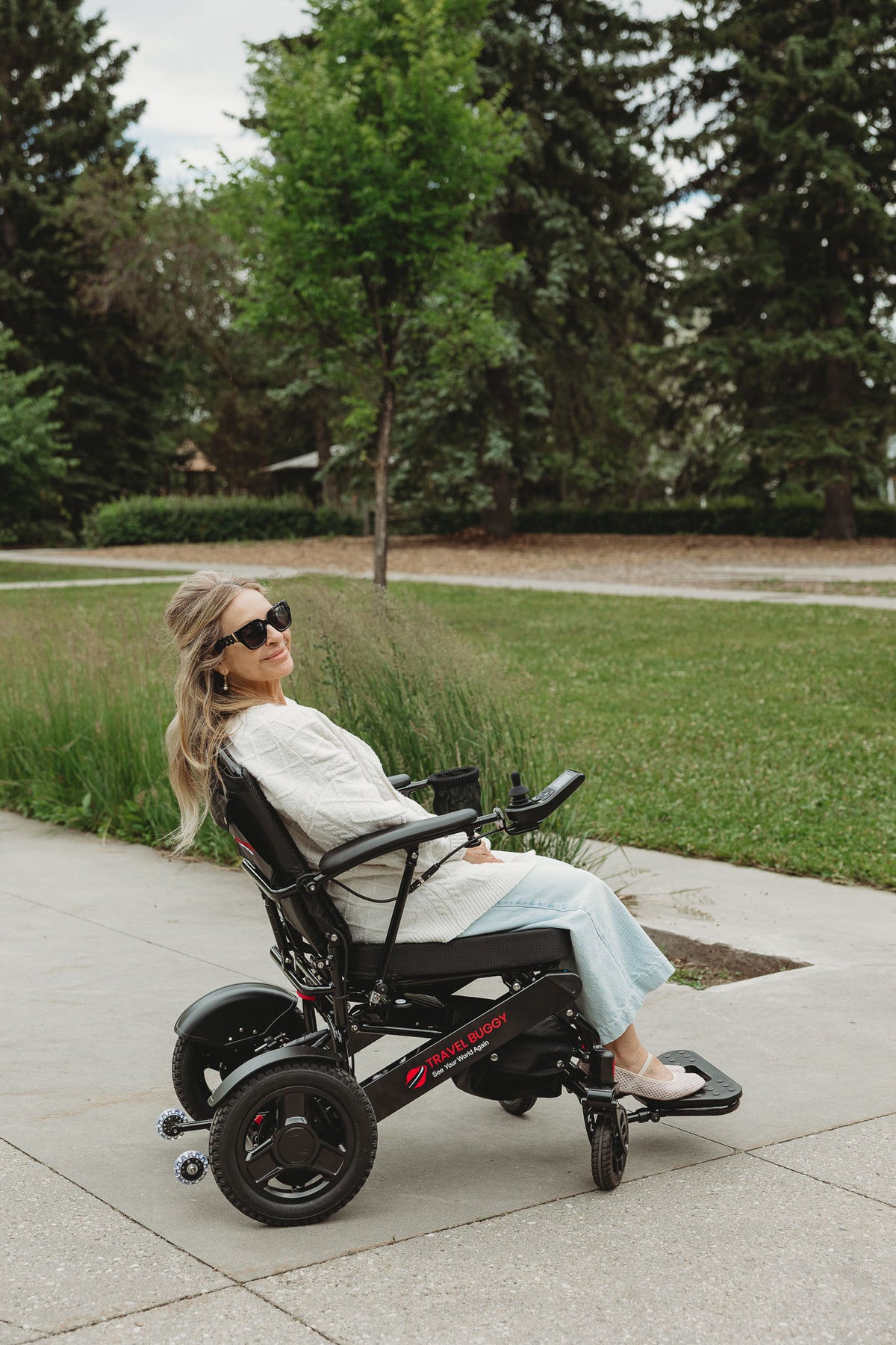 Person using a Black Travel Buggy CITY 2 PLUS power wheelchair on a park path
