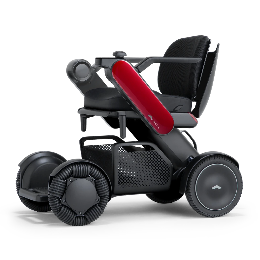 WHILL Model C2 power wheelchair with red arm covers, front three-quarter studio view