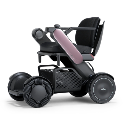 WHILL Model C2 power wheelchair with pink arm covers, front three-quarter studio view