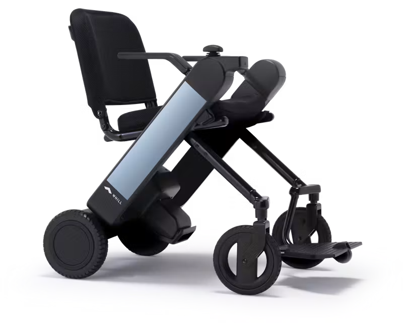 WHILL Model F power wheelchair with light blue arm covers, rear three-quarter studio view