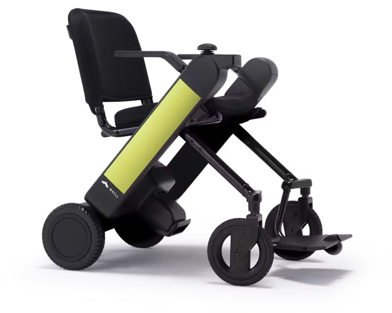 WHILL Model F power wheelchair with light green arm covers, rear three-quarter studio view