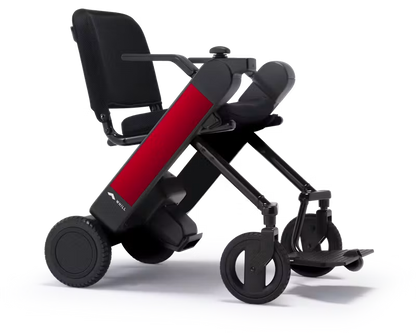 WHILL Model F power wheelchair with red arm covers, rear three-quarter studio view