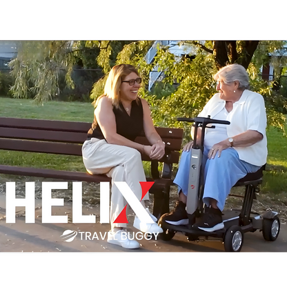Lifestyle image of a couple relaxing outdoors, with the man comfortably seated on the Travel Buggy HELIX scooter.