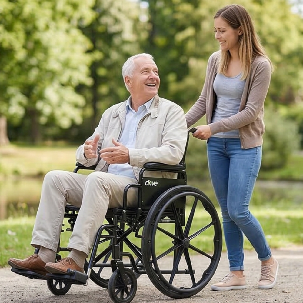 Lifestyle shot of a woman pushing a man in the Cruiser X4 wheelchair along a sunny outdoor park path.