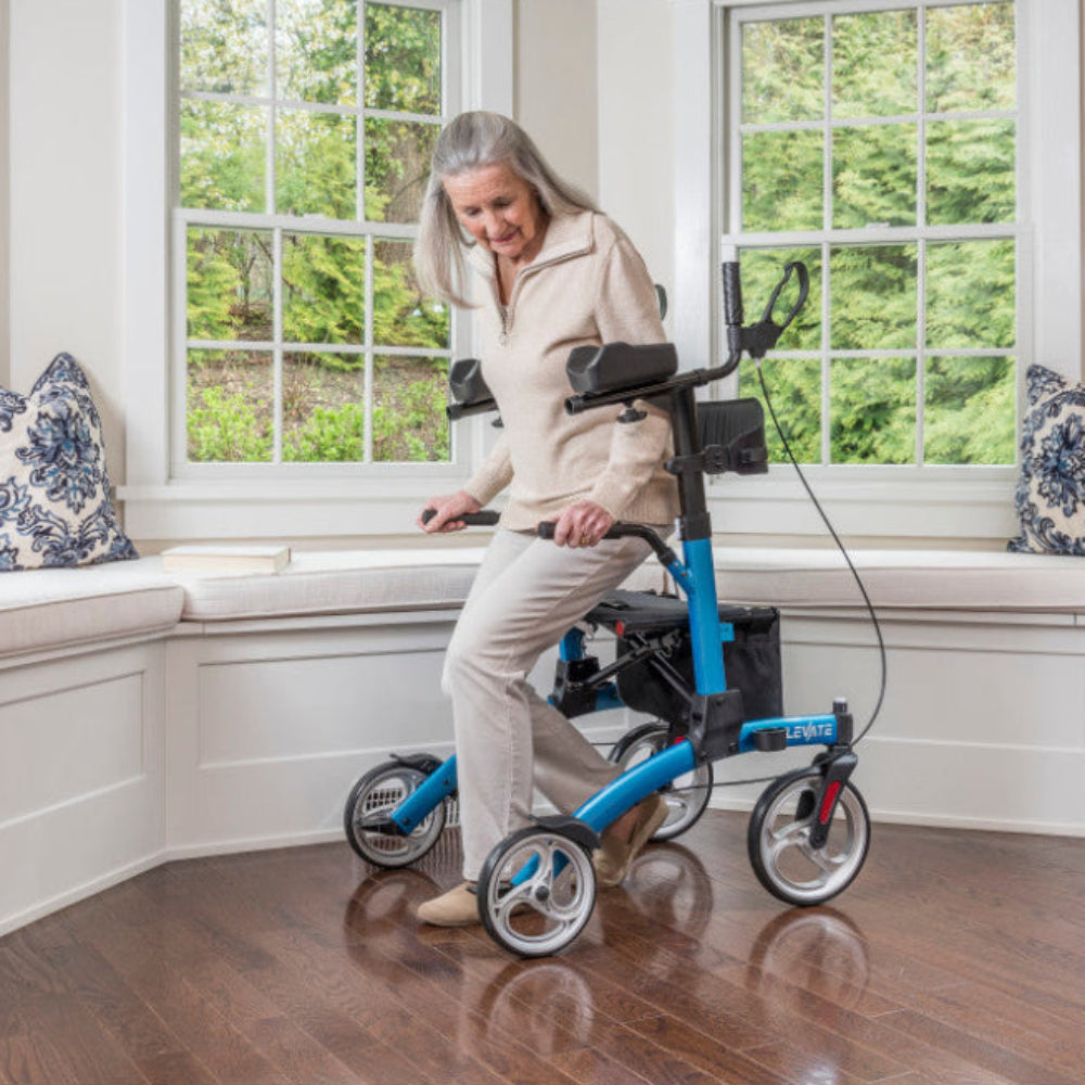 Woman rising beside a Blue Drive Medical Elevate upright walker indoors