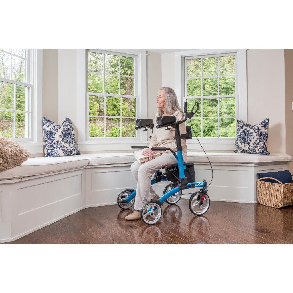 User sitting comfortably on the padded seat of the Drive Elevate Upright Walker outdoors.
