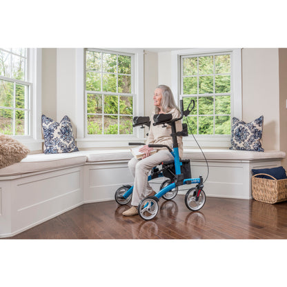 User sitting comfortably on the padded seat of the Drive Elevate Upright Walker outdoors.