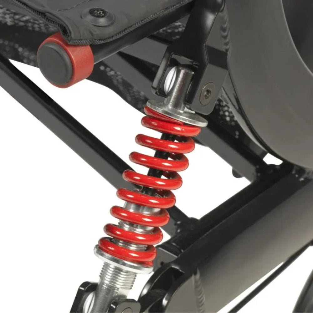 Detailed view of the red shock-absorbing front suspension spring on the Drive Medical Nitro HD rollator for a smooth outdoor ride.