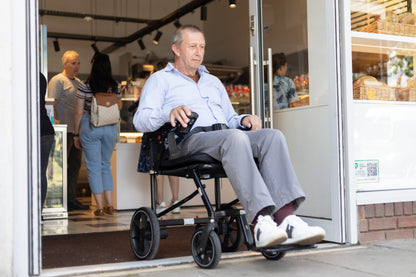 eFOLDi Navigator power wheelchair being used outside a shop