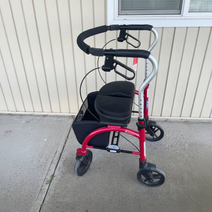 Side profile of the red Evolution Xpresso Lite rollator indoors, highlighting its smooth-rolling 4-wheel design and ergonomic handles.