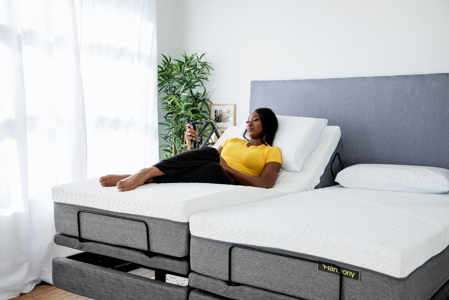 Woman using Harmony remote with one side of bed raised