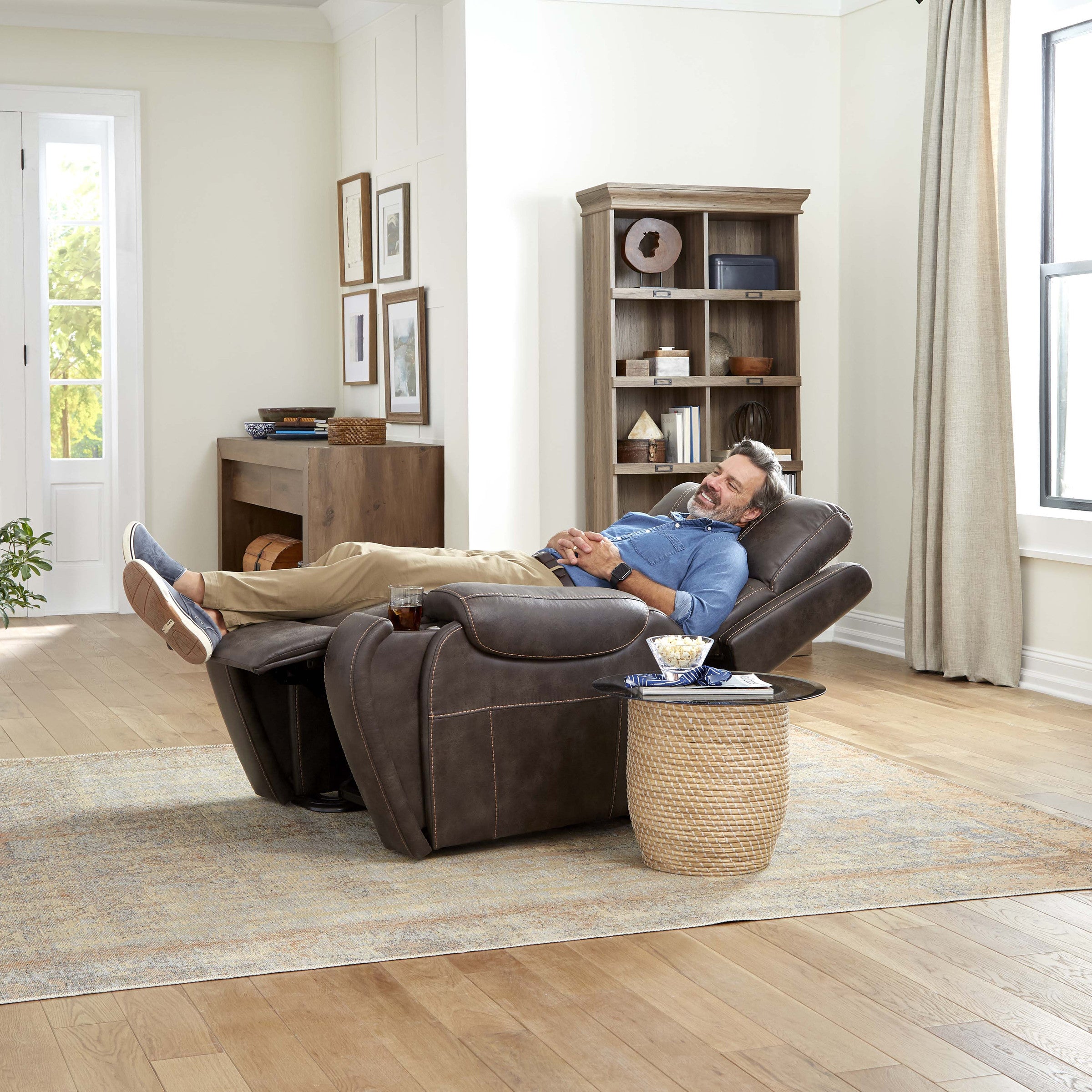 Lifestyle shot of a man relaxing comfortably in his living room while seated in the Golden Titan PL449 lift chair.