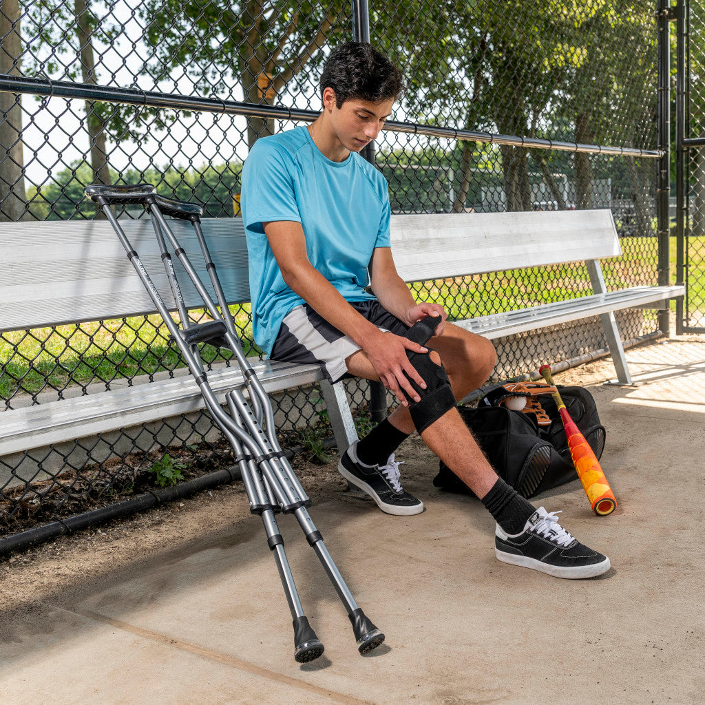 Man resting on a park bench with her sleek black Drive Medical Air-Crutches leaning conveniently nearby.
