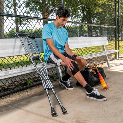 Man resting on a park bench with her sleek black Drive Medical Air-Crutches leaning conveniently nearby.