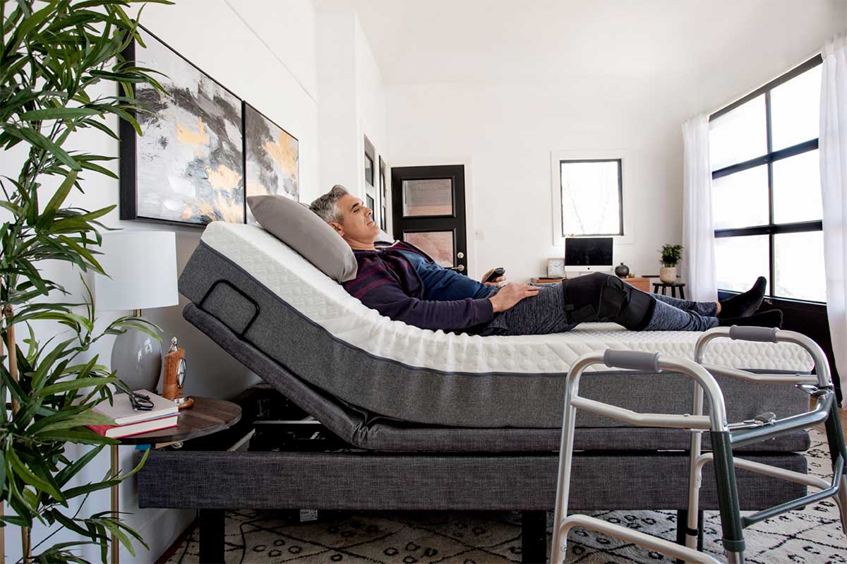 Lifestyle shot of a man resting comfortably in the contoured, zero-gravity position on the Harmony Hi-Low bed.