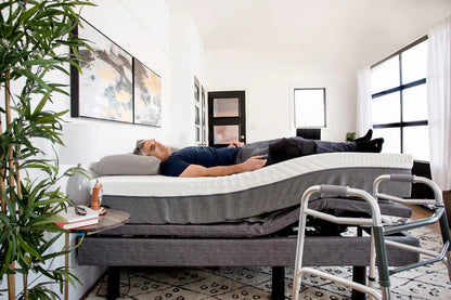 Lifestyle shot of a man elevating legs on the edge of the flat Harmony Hi-Low adjustable bed.