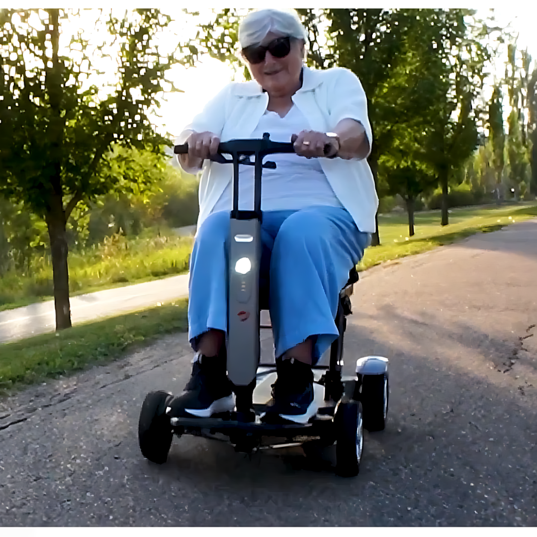 Lifestyle shot of a man enjoying a sunny day outdoors, riding the Travel Buggy HELIX scooter through a park.