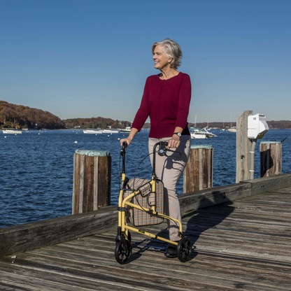 Senior man confidently using the Drive Medical Winnie Lite Supreme 3-wheel rollator outdoors on a scenic waterfront walking path.