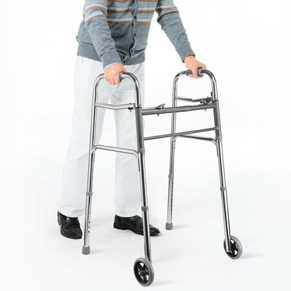 Lifestyle shot of a person safely navigating an indoor home hallway near a staircase using the Care Made folding walker with wheels.