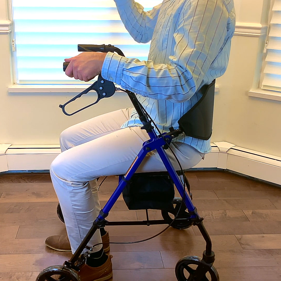 Lifestyle shot of a person comfortably using and adjusting the blue MOBB 4-wheel rollator inside a home setting.