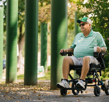 A man using the Pride Jazzy Carbon HD power wheelchair in a park