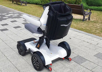 Lifestyle shot of the sleek Robooter X40 backpack securely mounted to the rear of a white X40 electric wheelchair outdoors.