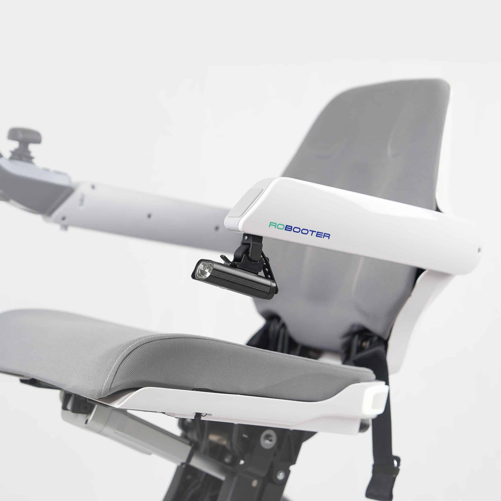 Side profile image showing the LED handrail lamp securely mounted to the armrest of the white Robooter X40 wheelchair for enhanced low-light safety.