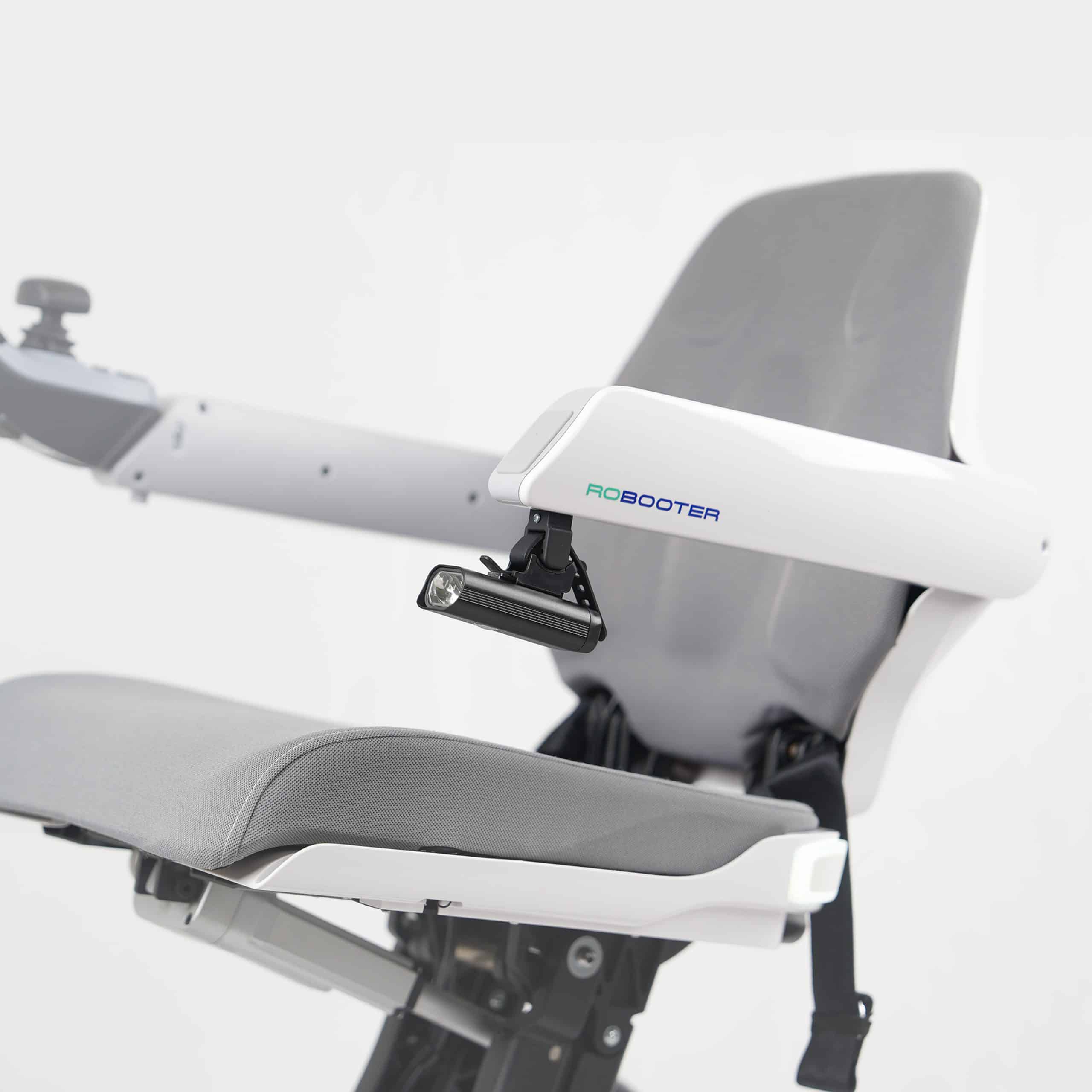 Robooter X40 headlamp fitted below the armrest of a white power chair
