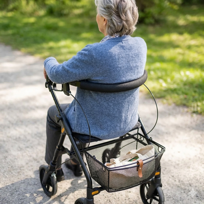 Lifestyle image of a senior man comfortably resting on the padded seat of the Evolution Piper Series rollator indoors.