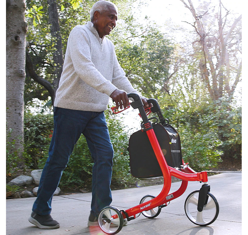 Lifestyle shot of a senior confidently walking along an outdoor path near the water using the agile Drive Medical Nitro 3-Wheel Rollator.
