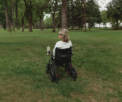 Woman seated in a Travel Buggy AEROLUX 2C in a park, viewed from behind