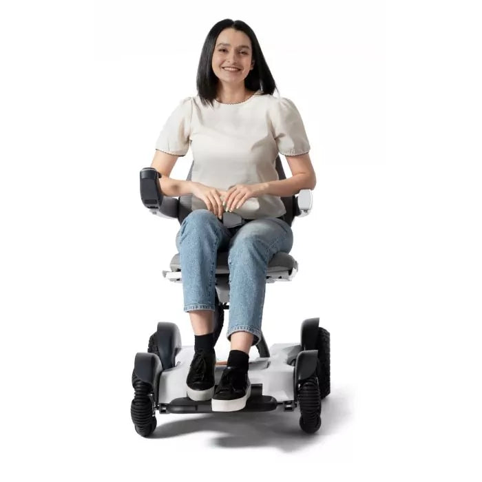 Woman smiling confidently while driving the sleek, modern Robooter X40 power wheelchair smoothly indoors.