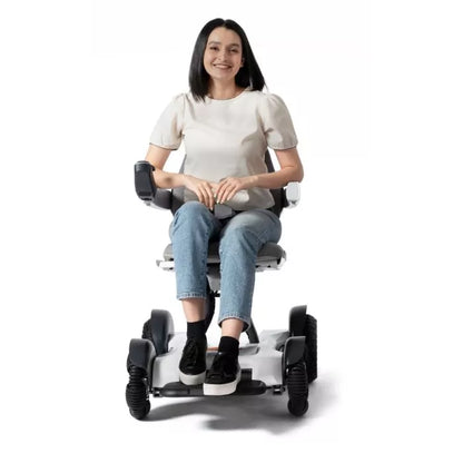 Woman smiling confidently while driving the sleek, modern Robooter X40 power wheelchair smoothly indoors.