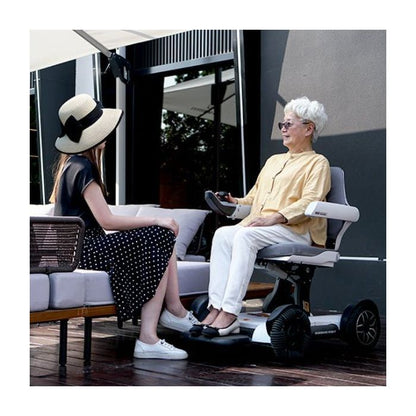 Lifestyle shot of a woman enjoying an outdoor patio space while seated in the comfortable Robooter X40 power chair.