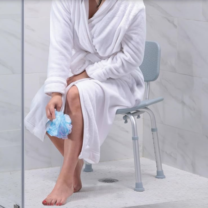 Lifestyle image of a woman in a bathrobe sitting securely on the Drive Medical bath chair inside a standard tub.